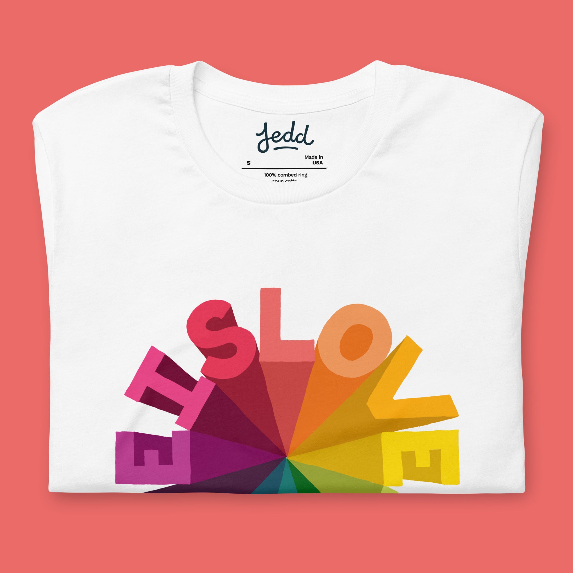 White t-shirt with colorful 'LOVE' design and brand name on a pink background