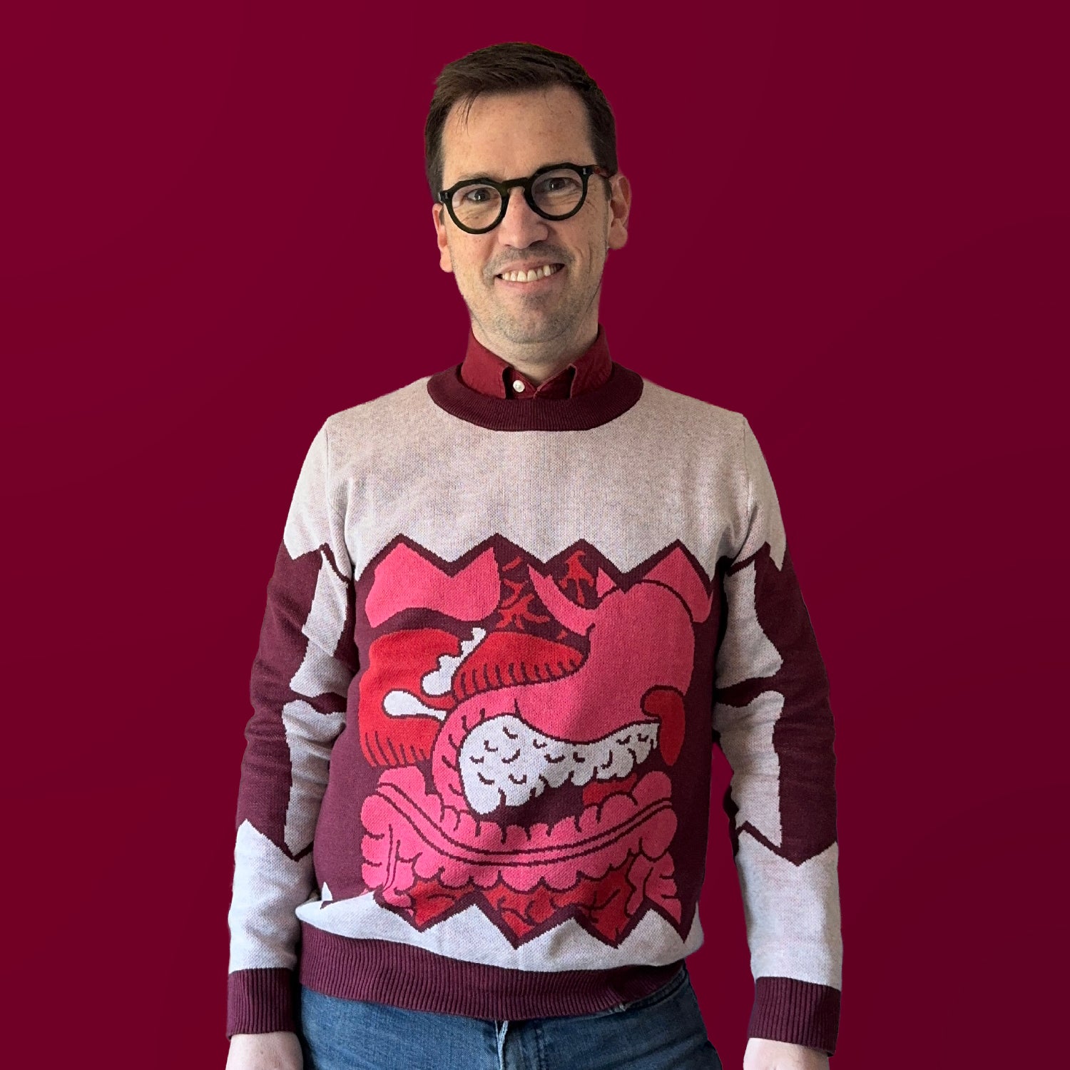Jedd wearing a gray sweater with a detailed illustration of guts over the stomach.