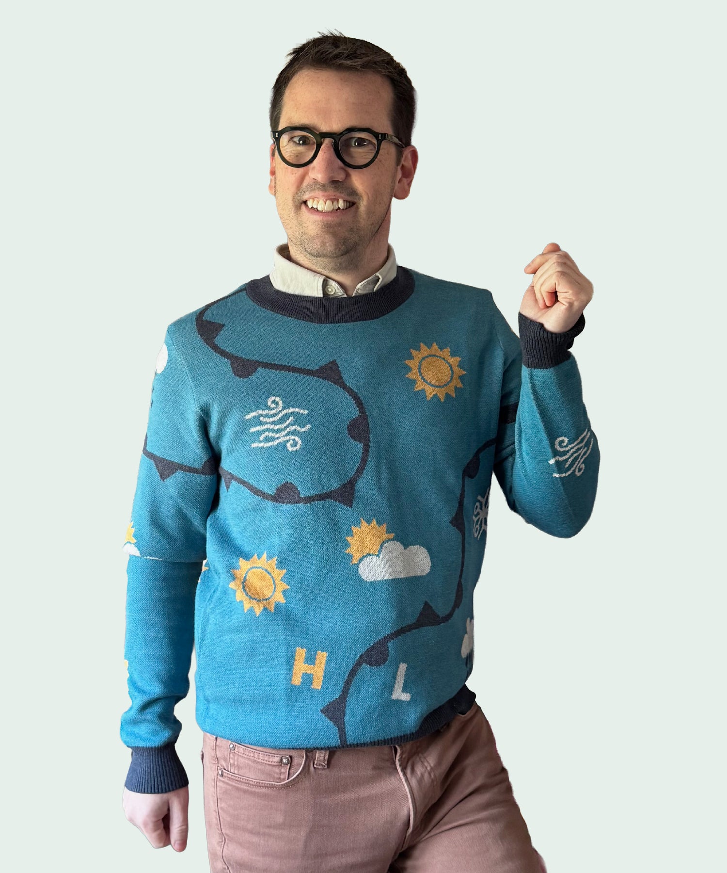 Man wearing a blue sweater with shark and sun designs on a light gray background
