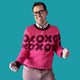 Jedd wearing a pink sweater with an XOXO design