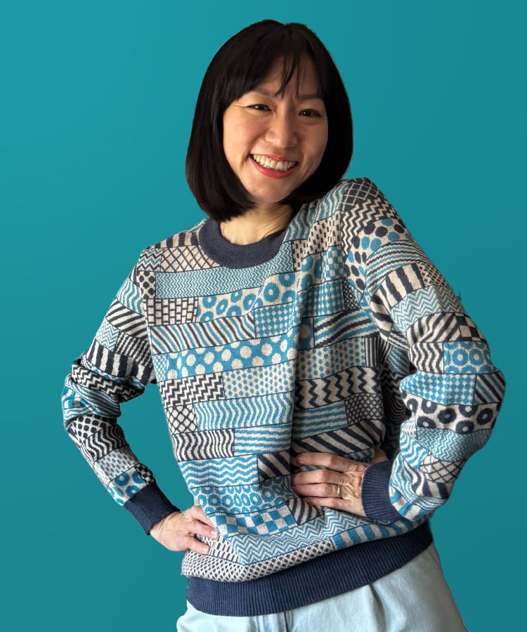 Woman wearing a patterned sweater against a blue background