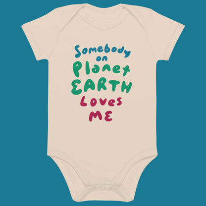Beige baby onesie with colorful text that says Somebody on Planet Earth Loves me